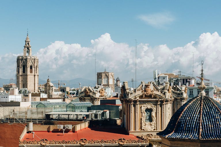 Skyline of Valencia with historic architecture and towers under a bright sky.